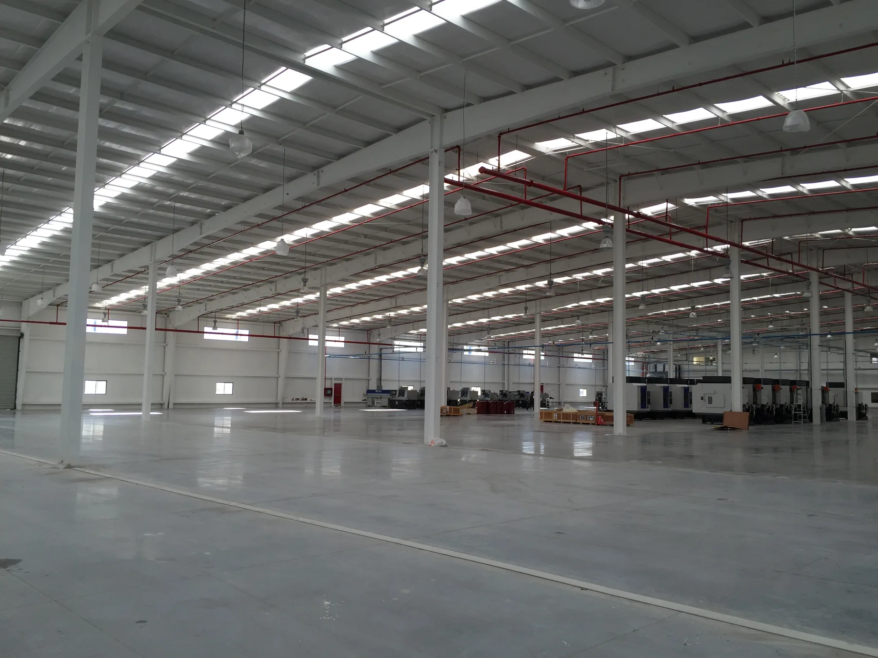 Open factory floor with steel columns and skylights
