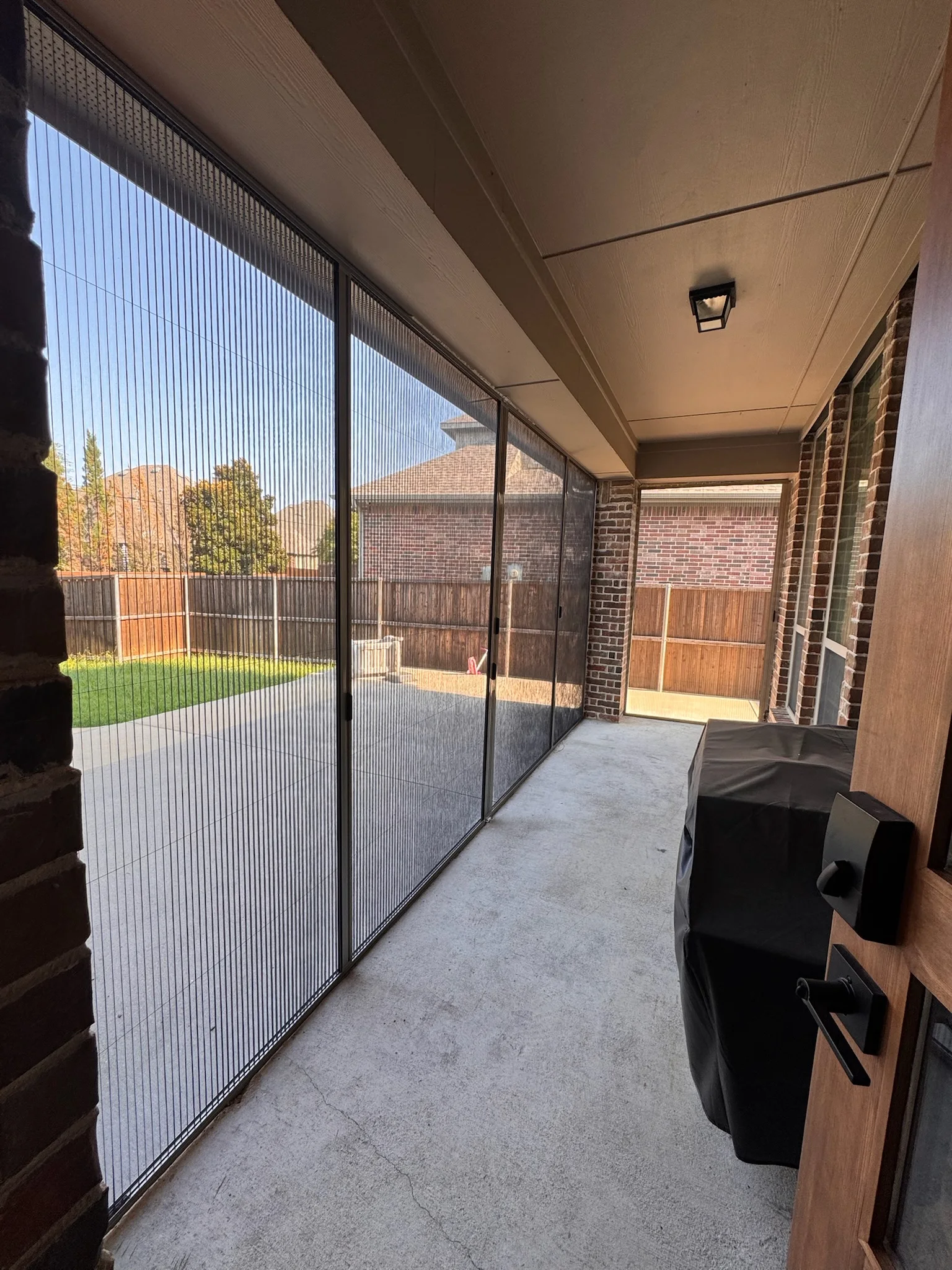 Interior view of pleated screens along a covered patio