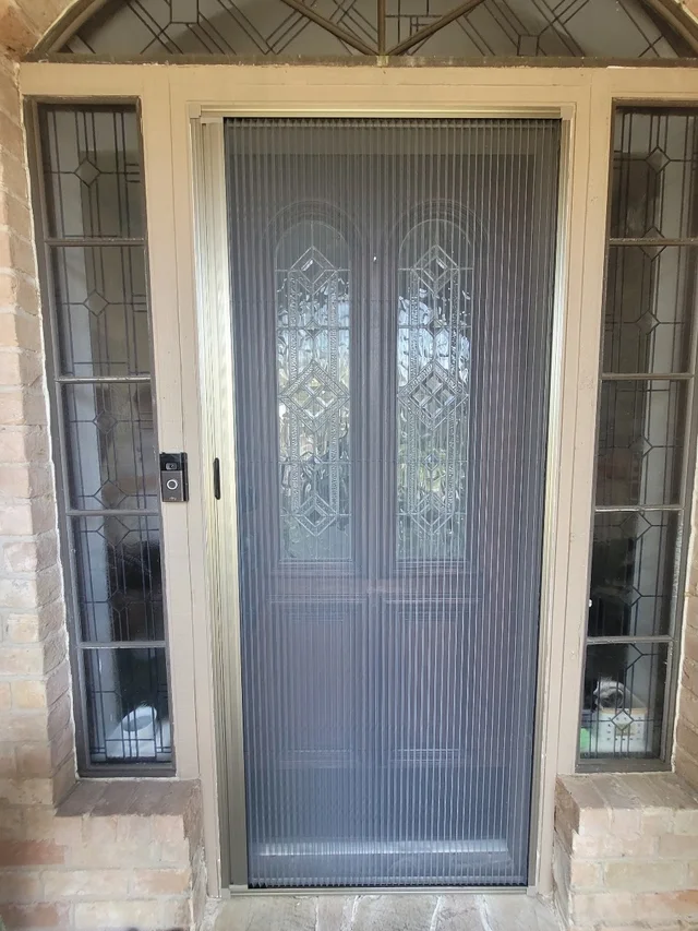 Single-handle pleated screen fitted to a front door
